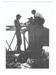 Two Crane Operators Standing On Crane by Blue Cross and Blue Shield of Florida, Inc.