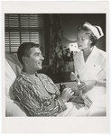 Promotional Photograph: Man In Hospital Bed Holding Insurance Card by Blue Cross and Blue Shield of Florida, Inc.